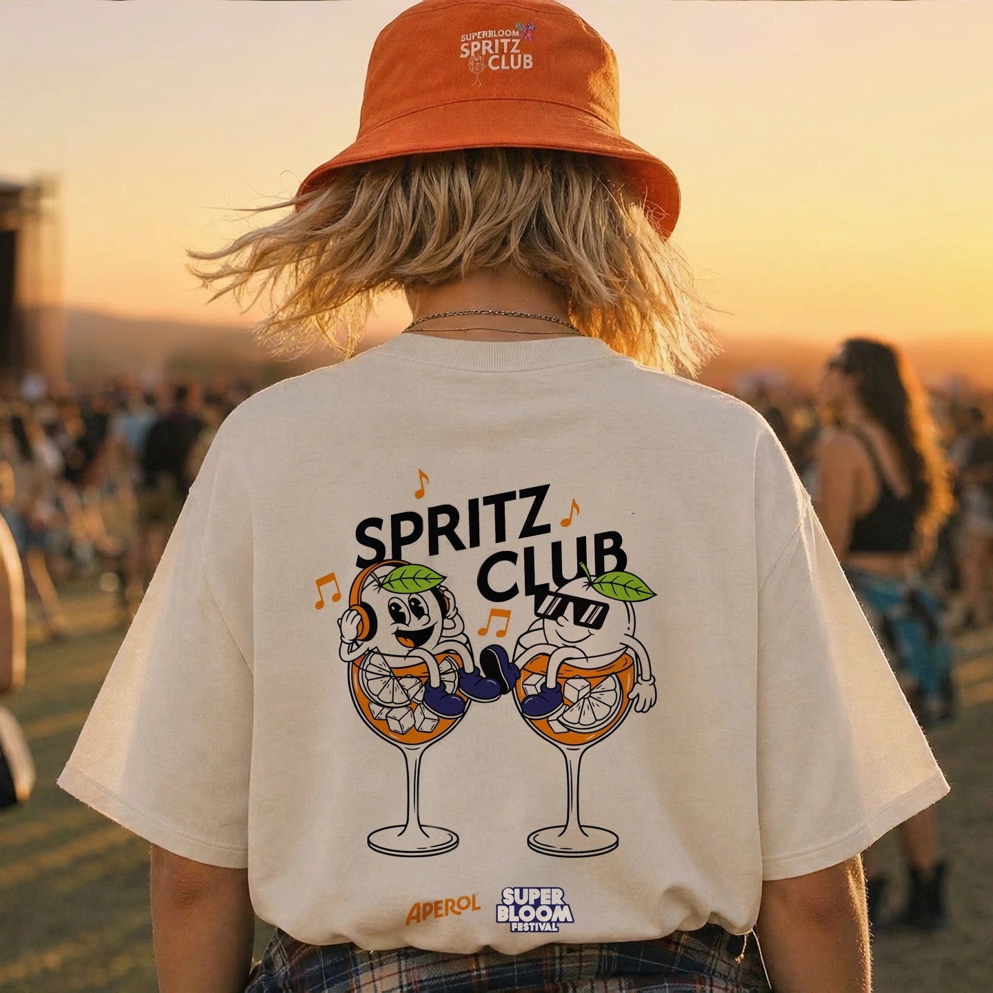 Rückansicht einer Person im cremefarbenen Aperol x SUPERBLOOM T-Shirt mit SPRITZ CLUB Druck.