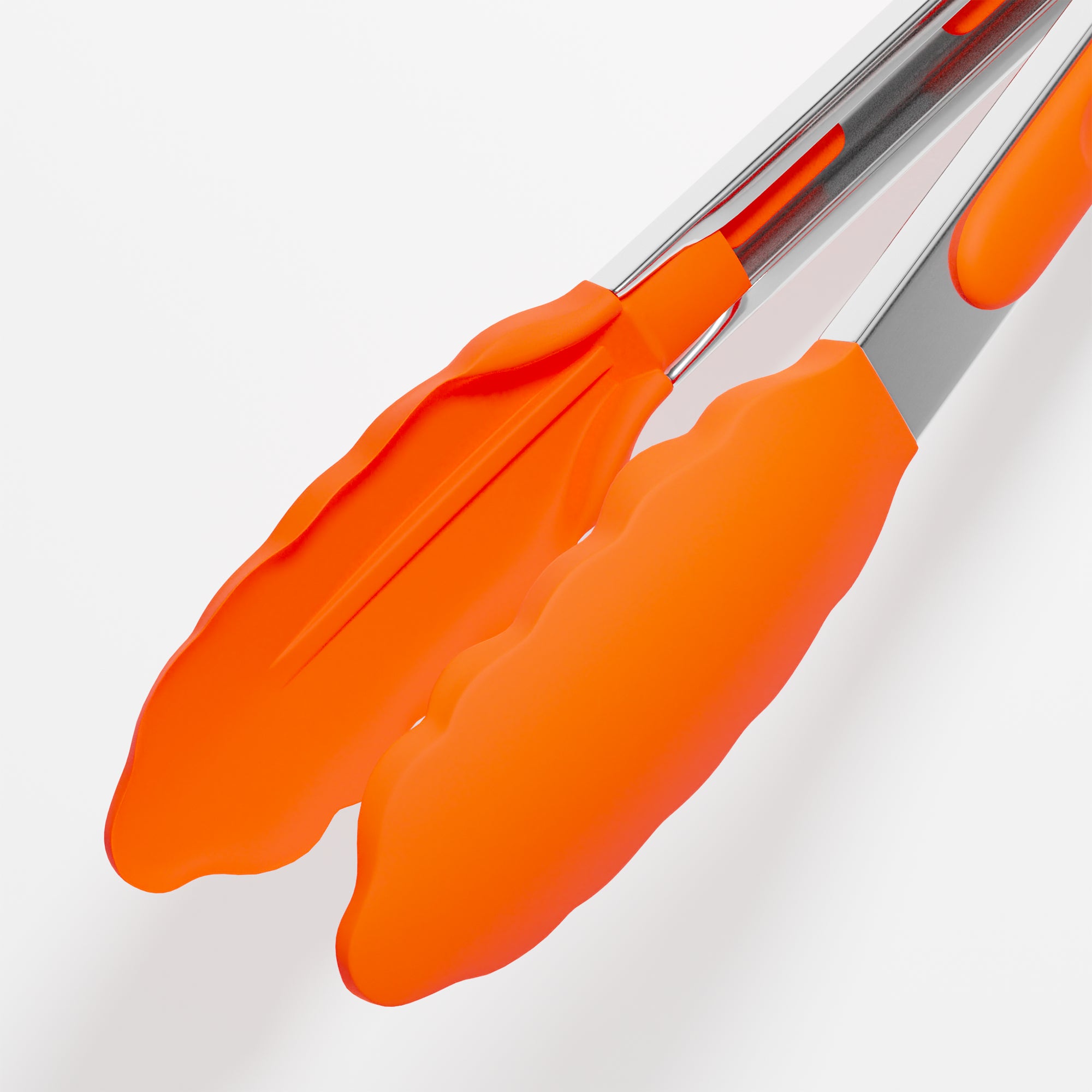Stainless steel kitchen tongs with bright orange silicone tips, featuring ergonomic handles and a scalloped design.