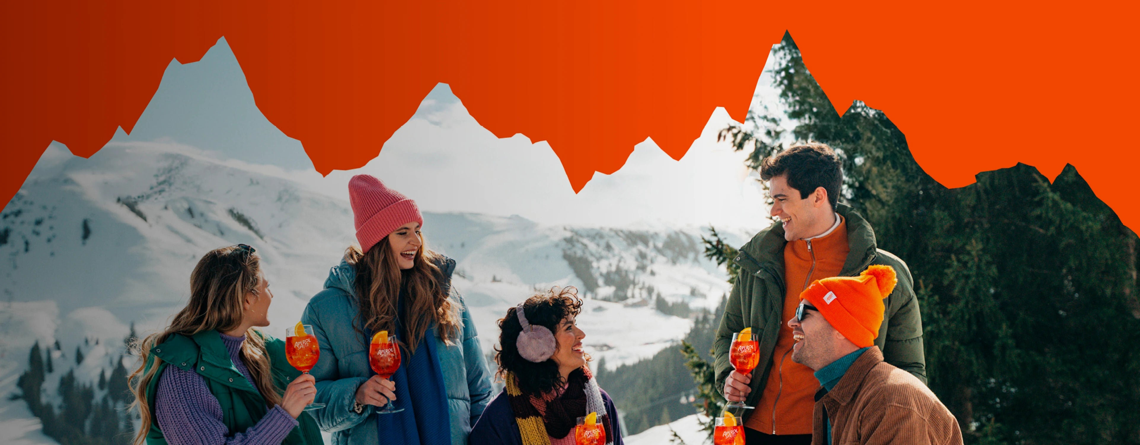Group of friends enjoying Aperol Spritz in colorful winter clothes with snowy mountains in the background
