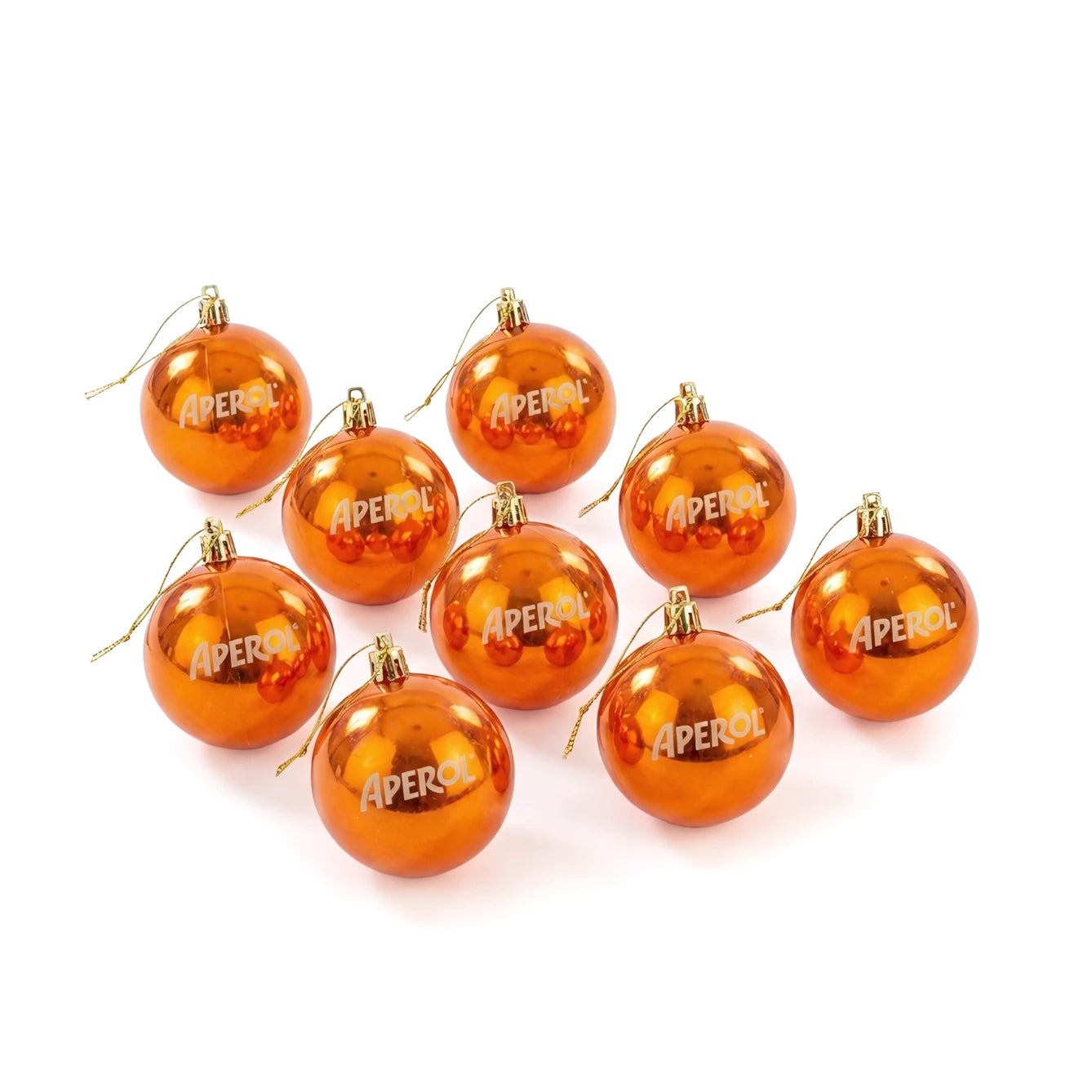 Nine shiny orange Christmas baubles with gold caps and hangers, each printed with the word 'APEROL' in white, arranged on a white background.